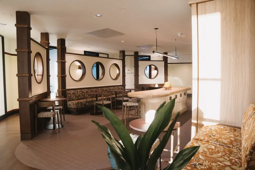 Kitchen and breakout area at The Work Project, featuring warm timber finishes, booth seating, circular wall openings and integrated Artus Air units.